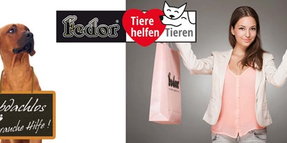 Händler - Lieferservice - Frösau - Das Bild zeigt eine Frau mit zwei Einkaufstaschen in Ihren Händen. Daneben sitzt ein großer brauner Hund, der um seinen Hals eine Tafel trägt. Darauf steh geschrieben „Obdachlos – brauche dringend Hilfe!“  - Fedor® Tiernahrung