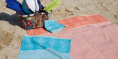 Händler - Versand möglich - Hupfau - Strandtücher bzw. Freizeittuch aus BIO-Baumwolle, mit eingewebten Botschaften. - verum textilia by Armin Landskron