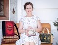 Unternehmen: Künstlerin Bernadette Hartl mit ihren Taschen aus Büchern vor ihrem Atelier sitzend in Steyr. - Bernanderl Upcycling