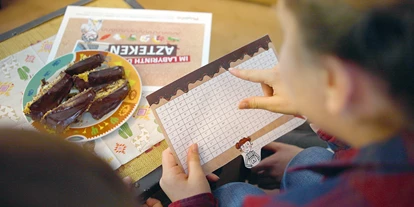Händler - Markt Allhau - Kinder spielen Escape Game zu Hause - Playcific