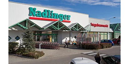 Händler - Unternehmens-Kategorie: Versandhandel - Aigen (Pyhra) - Eingang zu unserem Baumarkt in der Porschestrasse 29, 3100 Sankt Pölten - Baumarkt Nadlinger