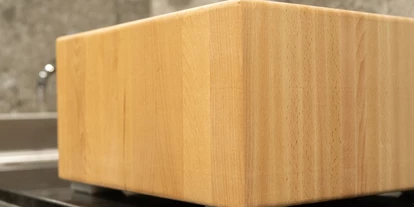 Händler - Utzenaich - Hackblock der auf Kunststoff-Fußplättchen auf einer Arbeitsplatte liegt - gastro HACKBLOCK manufaktur