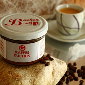 Unternehmen: Kaffeekuchen
mit flüssigem Bohnenkaffee, Nüssen, Schokolade und schokolierten Mokkabohnen - Backen mit Herz e.U.