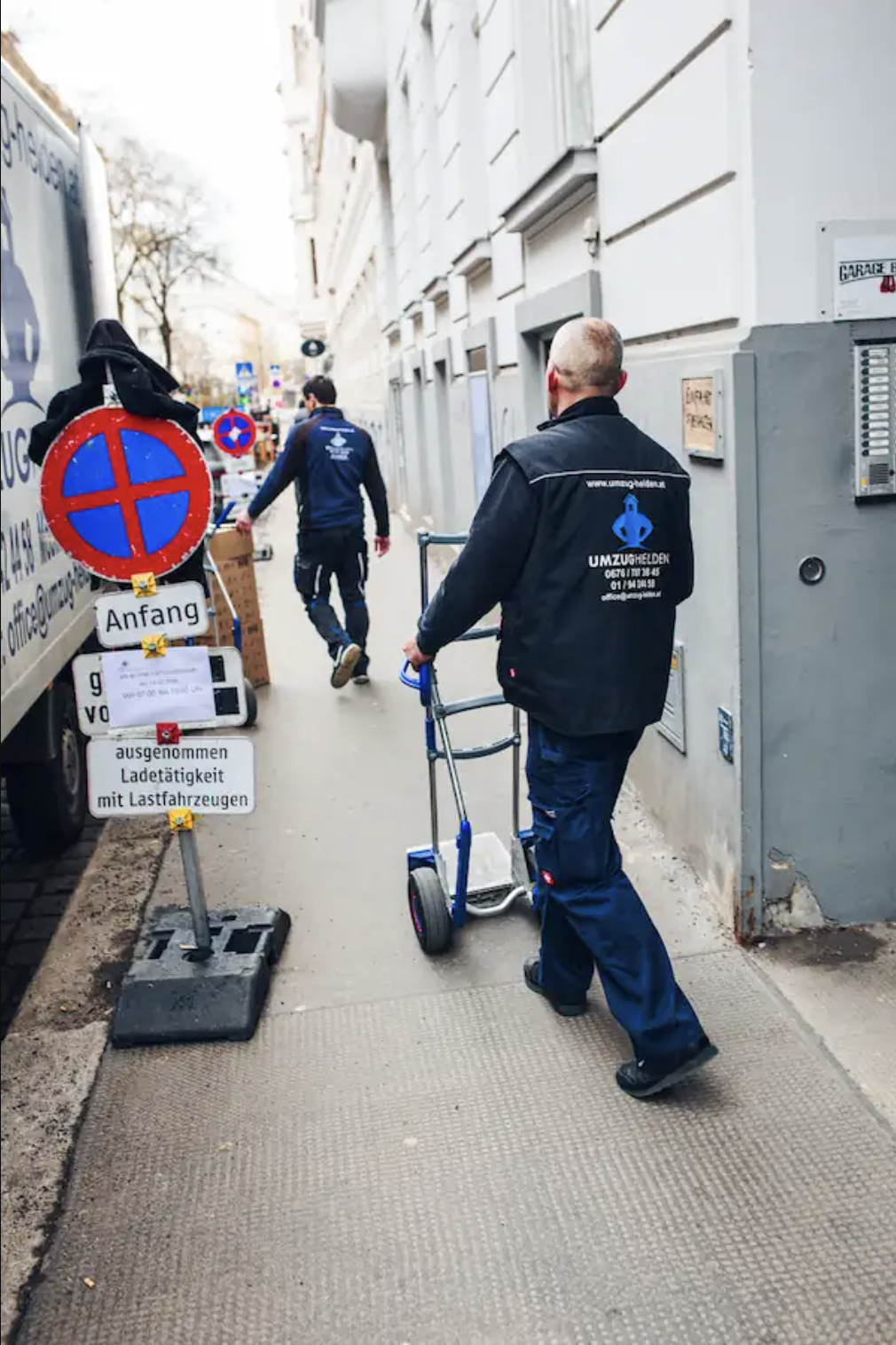 Betrieb: UmzugHelden Mitarbeiter mit Sackkarre neben Halteverbotszone in Wien vor Umzugs-LKW - UmzugHelden Wien