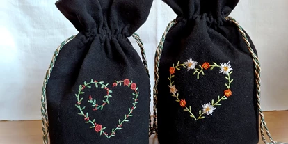 Händler - Innsbruck - Ein Herz aus Blumen verschönert die beiden Trachtenbeutel aus schwarzer Wolle. Liebevoll handgestickt mit echtem pflanzlich gefärbtem Seidenfaden.  - Alte Fäden - Historische Stickerei & Textile Accessoires