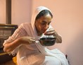 Unternehmen: Die Hausherrin beim Geschmackstest. Fr. Jemaneh röstet täglich auf traditionelle Weise mit der Pfanne. - ORIGINAL HABESHAWIT COFFEE 
